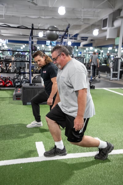 A personal trainer working with a senior at Fitness 19